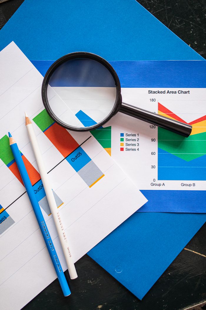 Image of financial charts and magnifying glass, ideal for business insights.